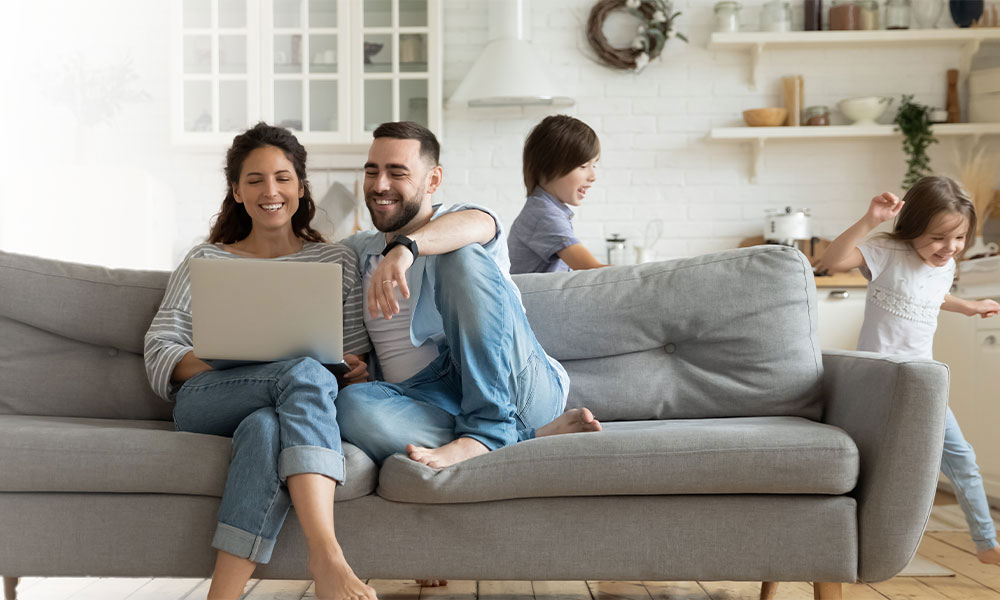 Family on a couch looking at a laptop