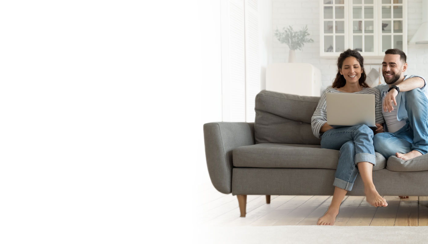 Family on a couch looking at a laptop