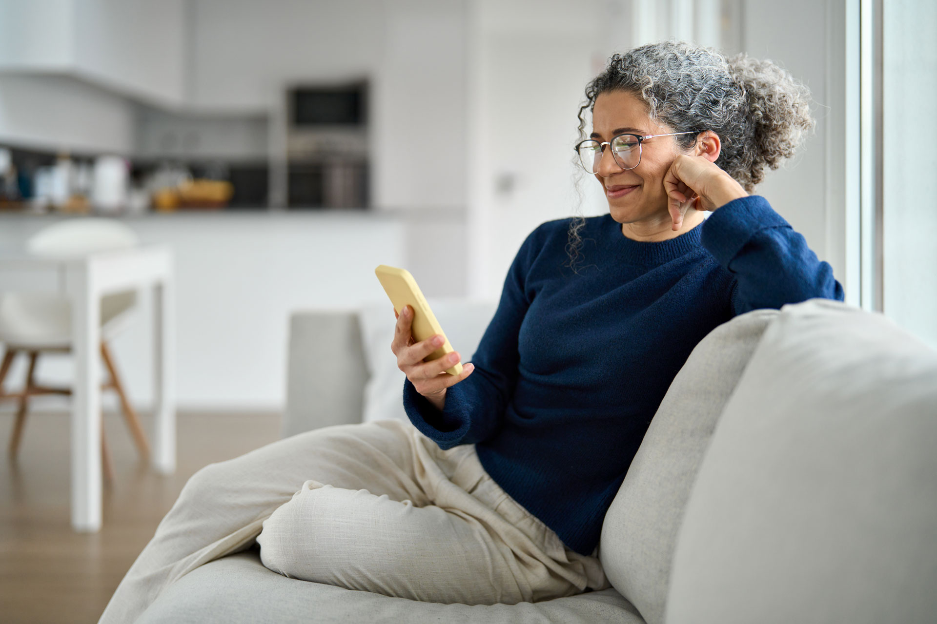 Girl on couch looking at her cell phone